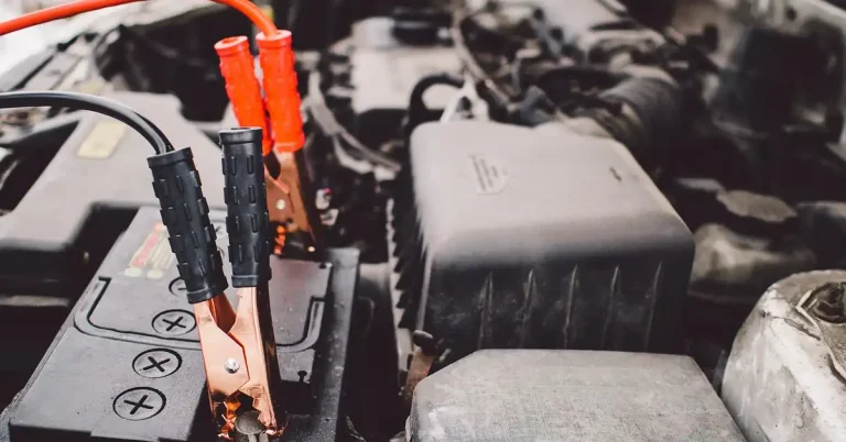 jumper cables connected to car battery under the hood