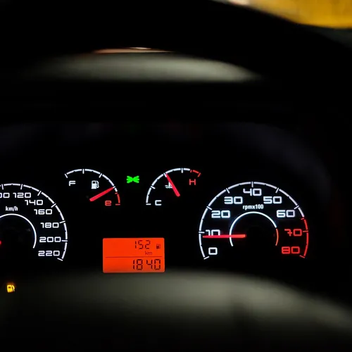 car dashboard showing speedometer and temperature gauge warning
