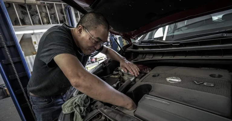 mechanic checking engine oil during a 5000 mile oil change
