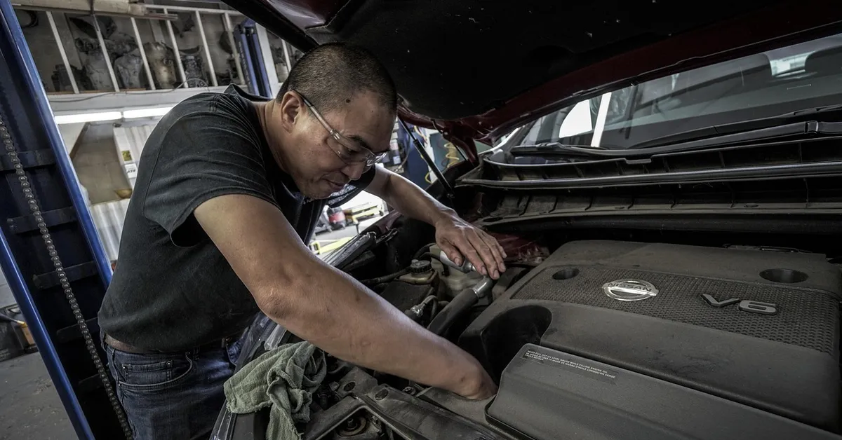 mechanic checking engine oil during a 5000 mile oil change