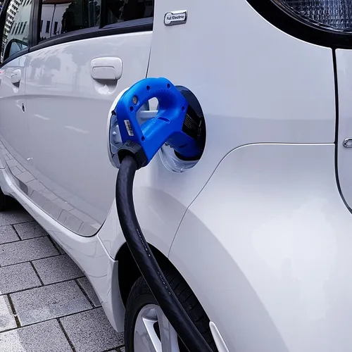 electric car plugged into charging station on UK road