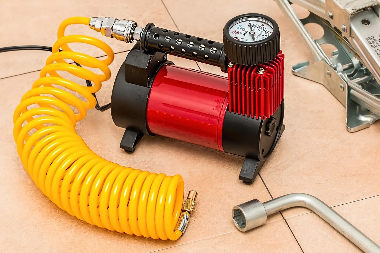 Driver checks a high-mileage car tire with a pressure gauge and tread depth tool in daylight.