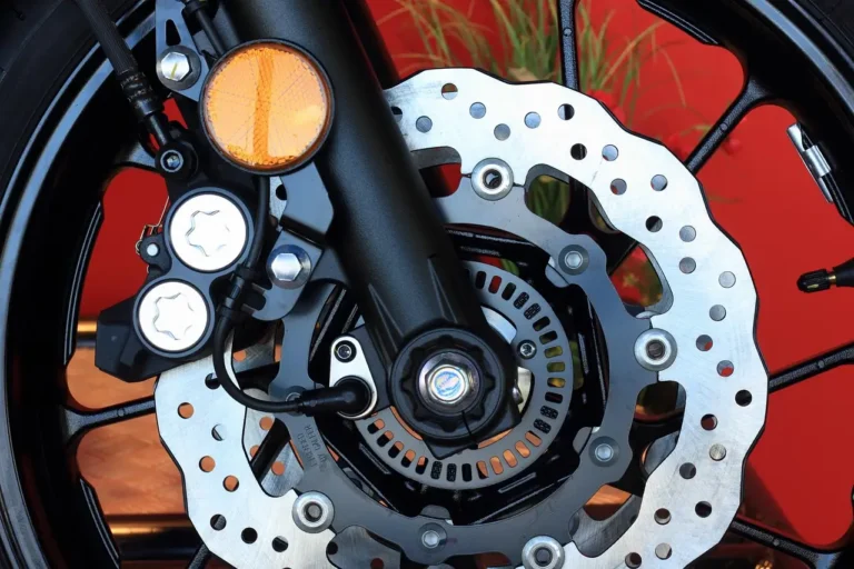 Mechanic inspecting a brake rotor and caliper on a car wheel in a garage