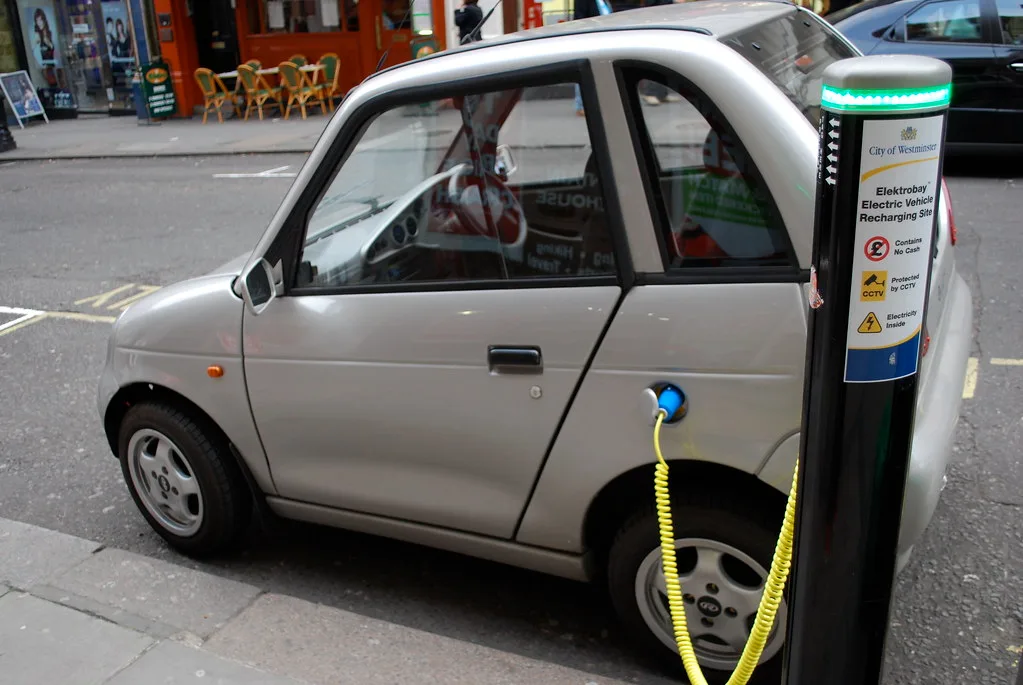 Charging plug inserted into an electric vehicle charge port in a garage