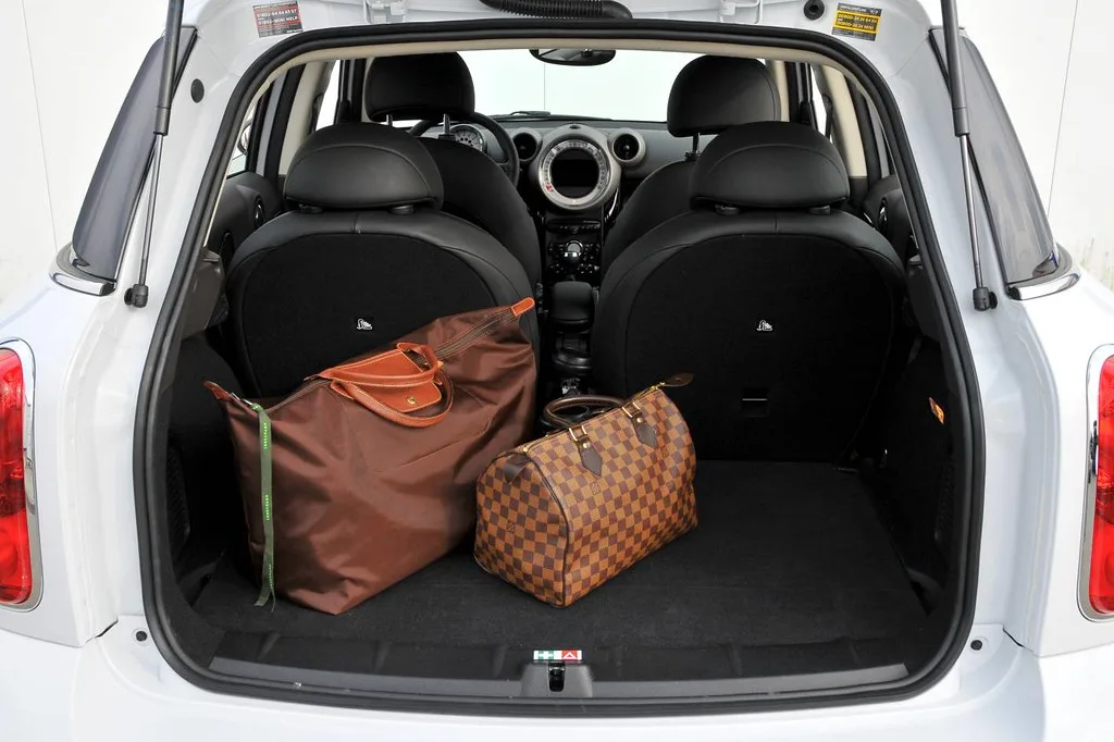 Hand folding a Ford SUV rear seat to show cargo space inside the cabin