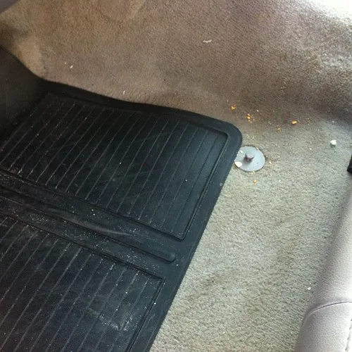 Hands budgeting car ownership costs with calculator, receipts, and car keys on a desk