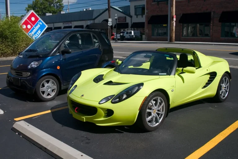 Couple and mechanic reviewing new, used, and certified pre-owned cars in a dealership lot