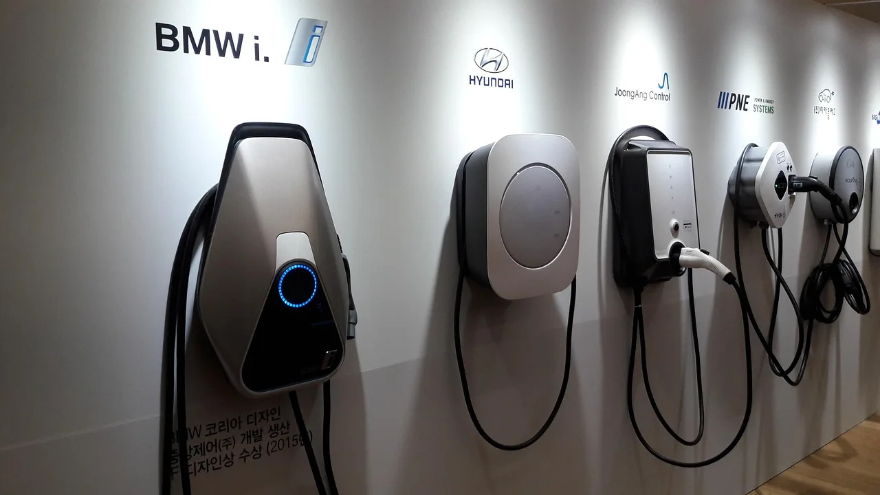 EV plugged into a home charger in a driveway at dusk