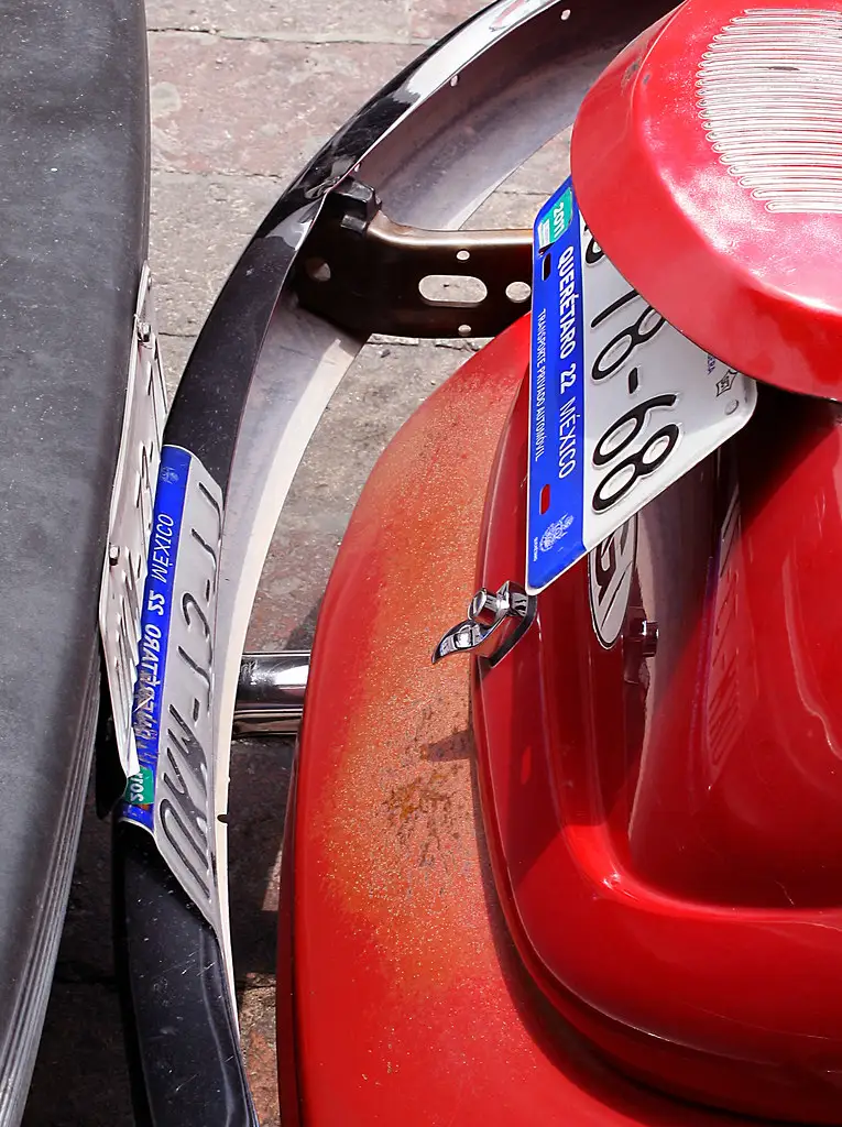 Close-up of a technician measuring tire tread and inspecting a wheel rim on a lift