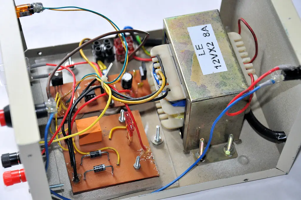 Battery maintainer clamp attached to a car battery terminal with indicator lights