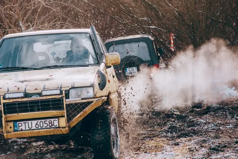 Compact crossover on a rough gravel road, showing suspension travel, tires, and ground clearance