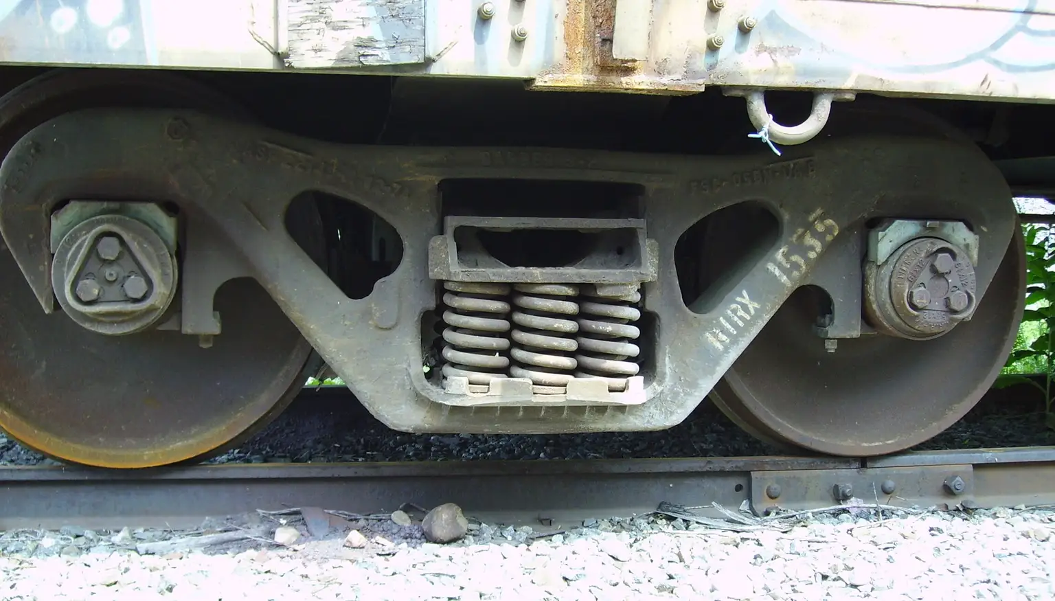 Close-up of a car wheel, tire sidewall, and suspension components on a lifted vehicle