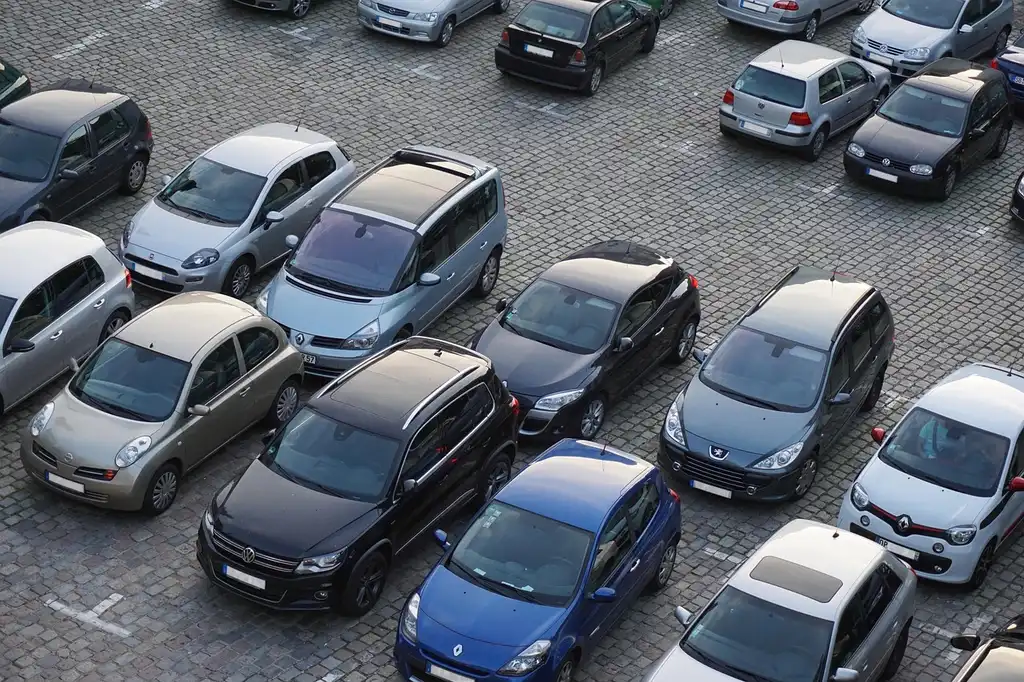 Compact hatchback parking easily on a narrow city street with other cars nearby