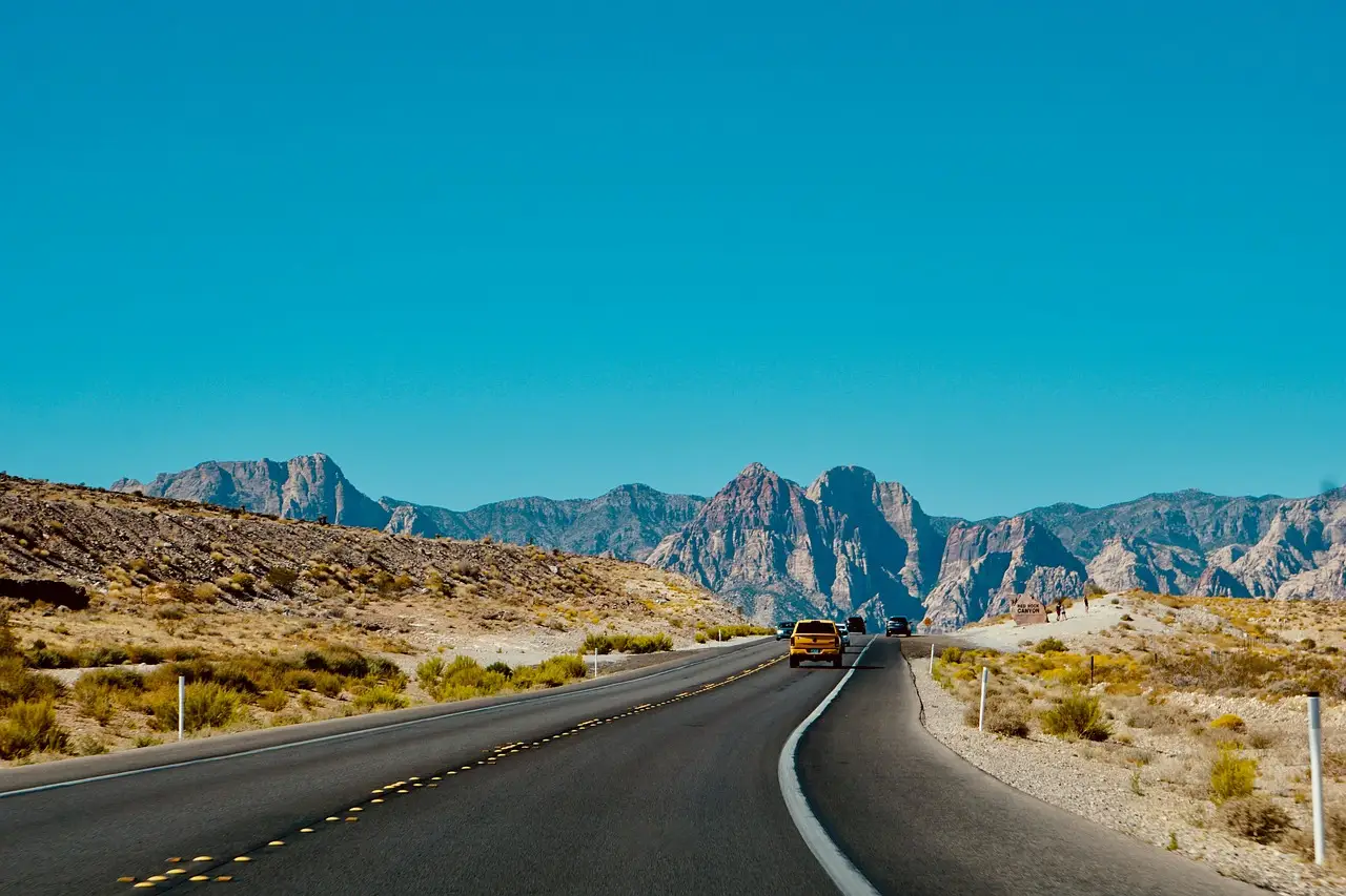 Comfortable sedan driving on a highway with a relaxed driver and bright natural light