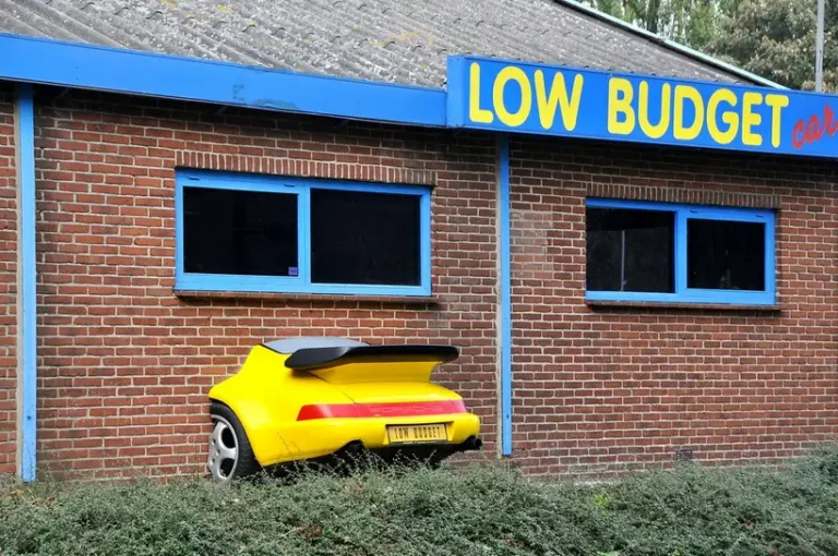 Ford Maverick parked in a driveway with a couple checking a budget sheet beside it