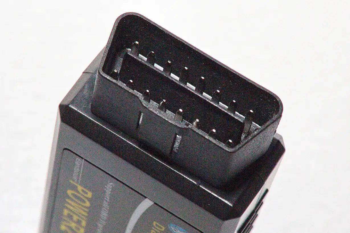 Close-up of an OBD2 scanner showing live transmission diagnostics in a mechanic's hands