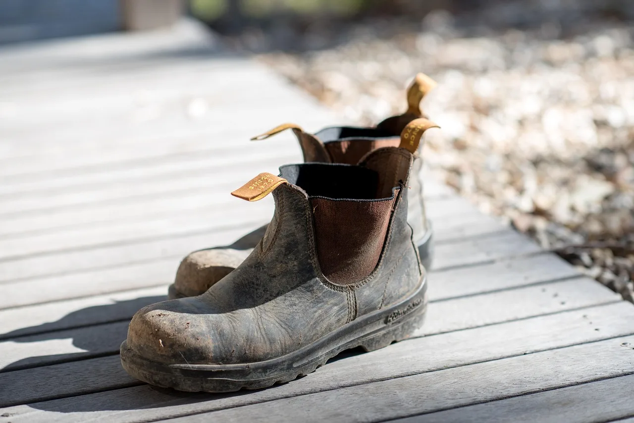 Booted foot on a textured pedal cover in a muddy winter street scene