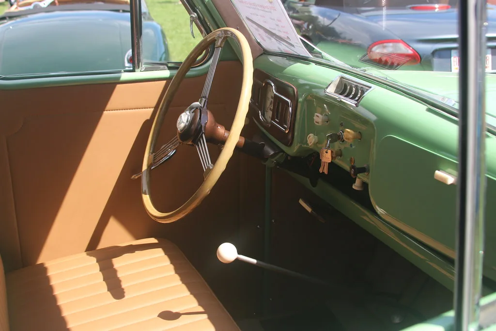 Pickup truck interior close-up with front seat, steering wheel, cupholders, and phone mount