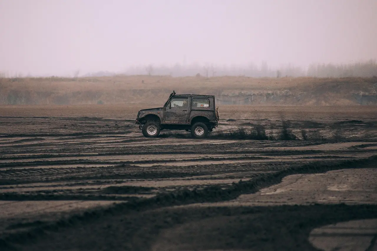 Beginner driver beside a compact SUV on a dirt trail in daylight