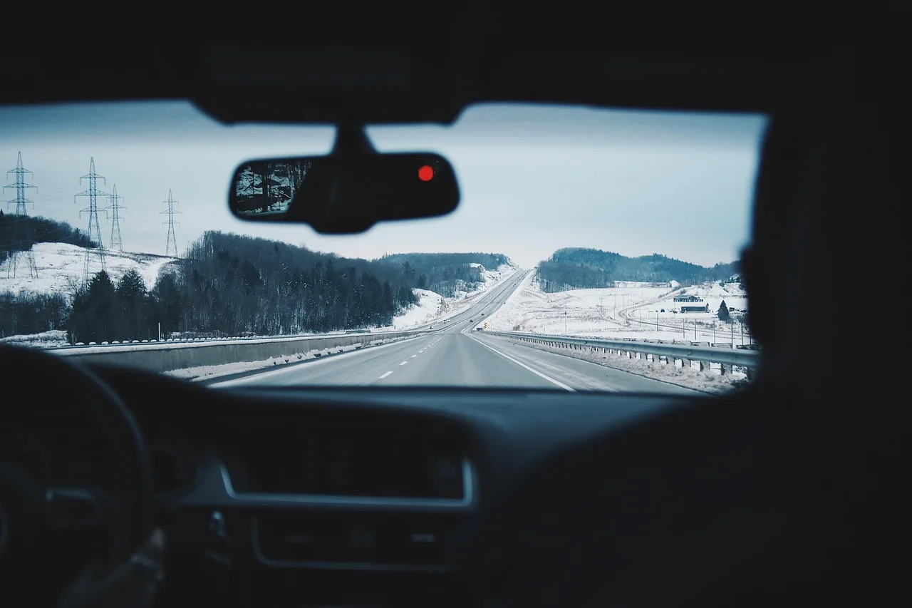 A compact SUV and a sedan on a snowy road, showing winter driving conditions