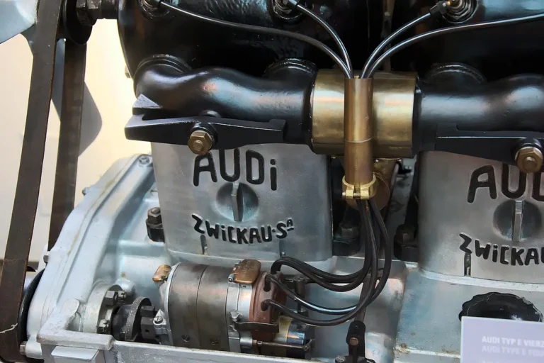 Open car engine bay with visible engine parts under natural light