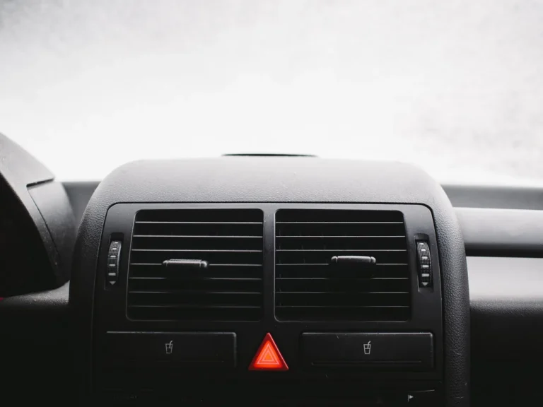 Car interior with dome and map lights visible while a hand inspects the overhead console