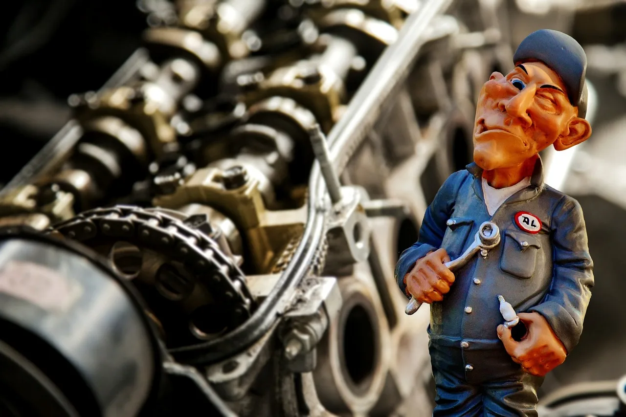 Mechanic comparing a manual, service records, and timing belt and chain parts in a repair bay