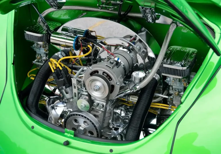 Mechanic inspecting a carburetor and fuel lines on a workbench under natural light