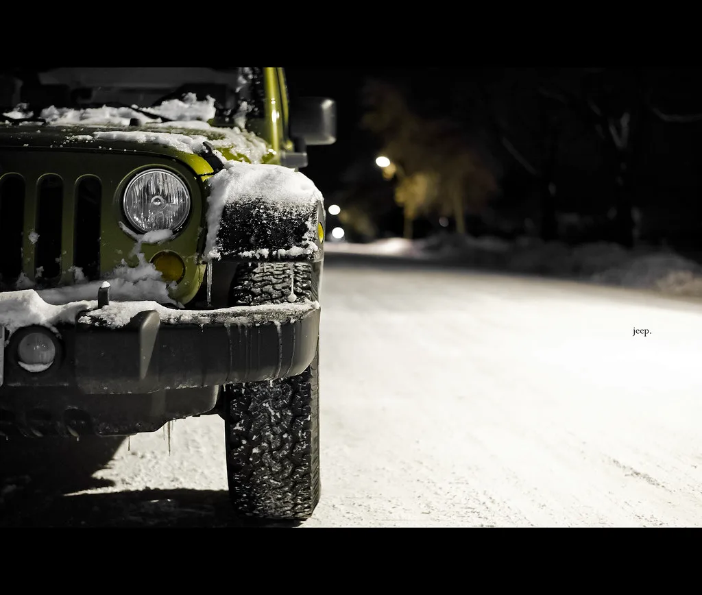 Chevy SUV parked on a wet snowy street at dawn in a suburban neighborhood