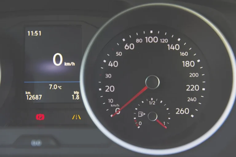 Chevy dashboard with warning lights glowing as a driver checks the gauges in daylight