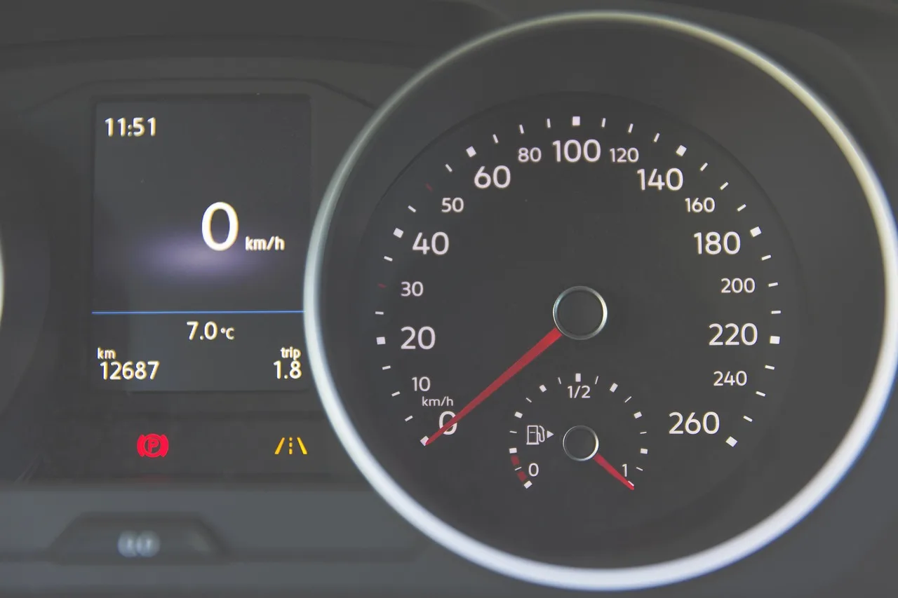 Chevy dashboard with warning lights glowing as a driver checks the gauges in daylight