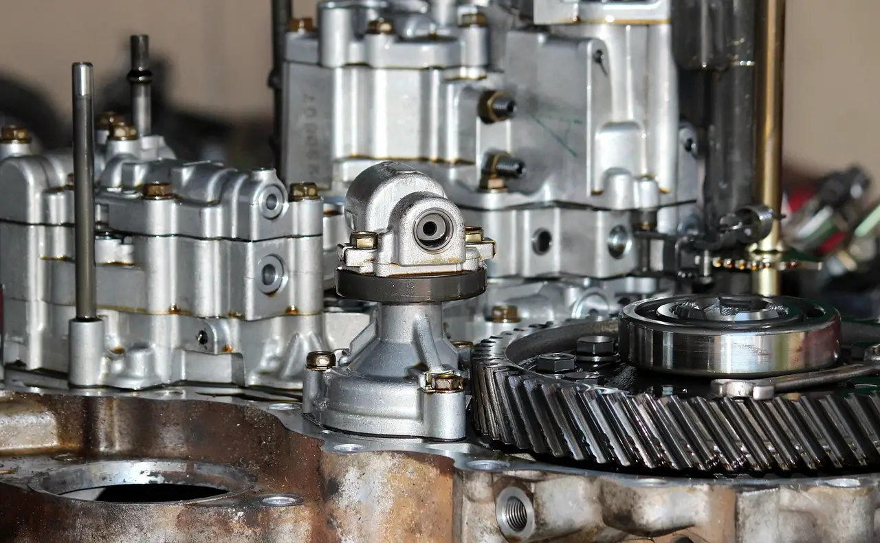 Chevy owner and mechanic discussing transmission symptoms beside a parked Chevrolet