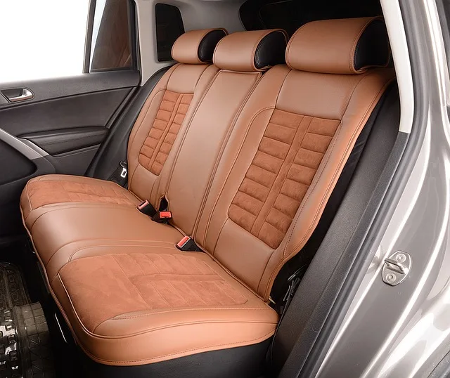 Close-up of a sedan rear door handle and back seat with a child seat visible.
