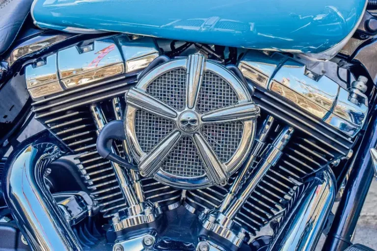 Mechanic pointing between an engine block and cylinder head in an open car engine bay