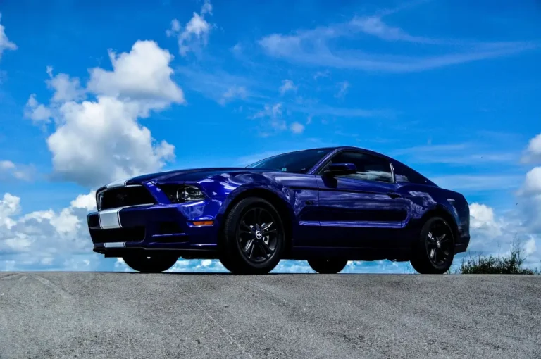 Ford Mustang EcoBoost and GT parked side by side at a sunlit overlook