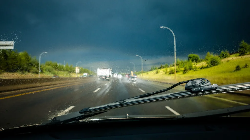 Close-up of a Honda Civic wiper blade lifted from the windshield with rain droplets