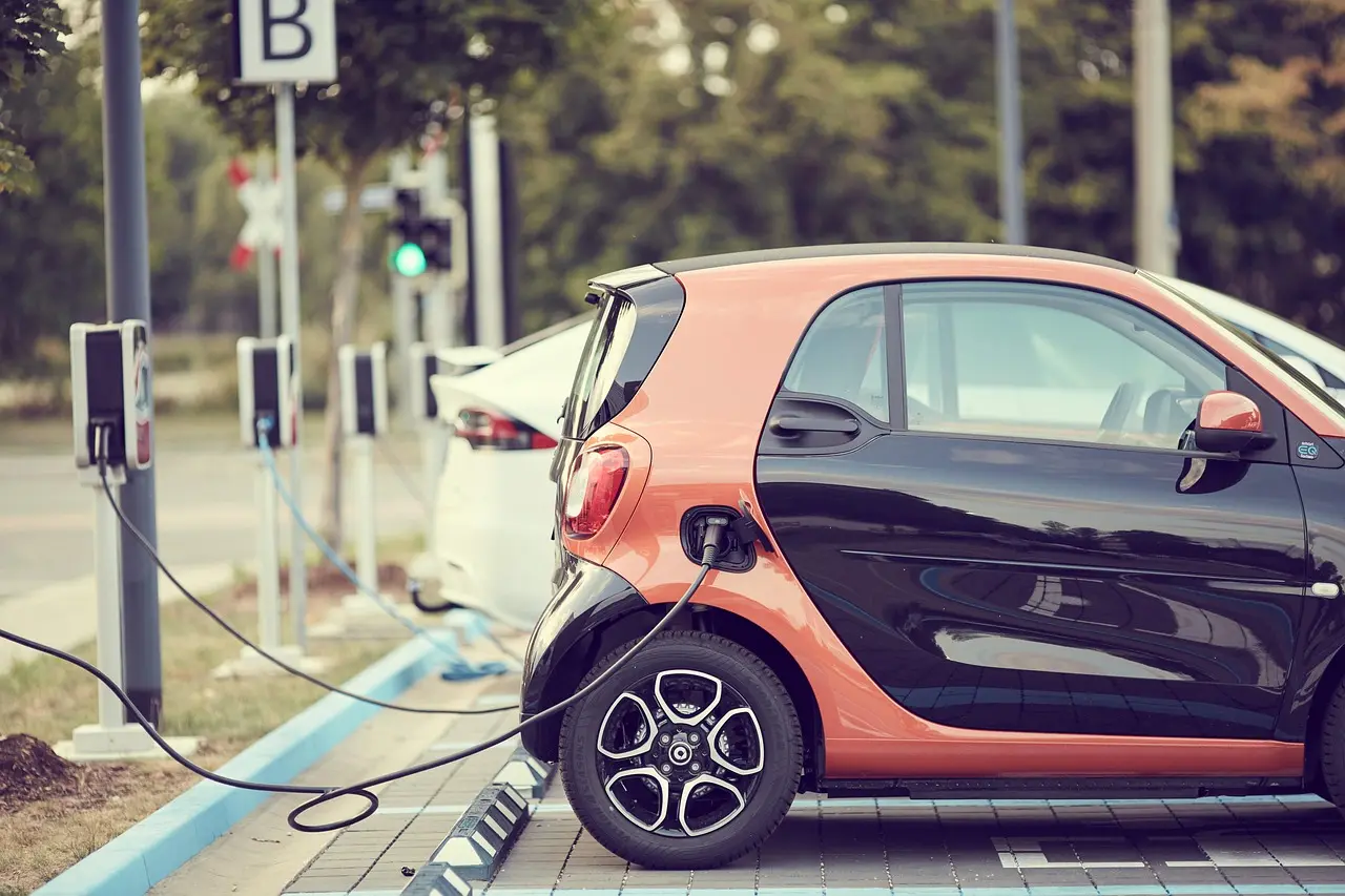 Driver checking an electric car while it charges in a driveway
