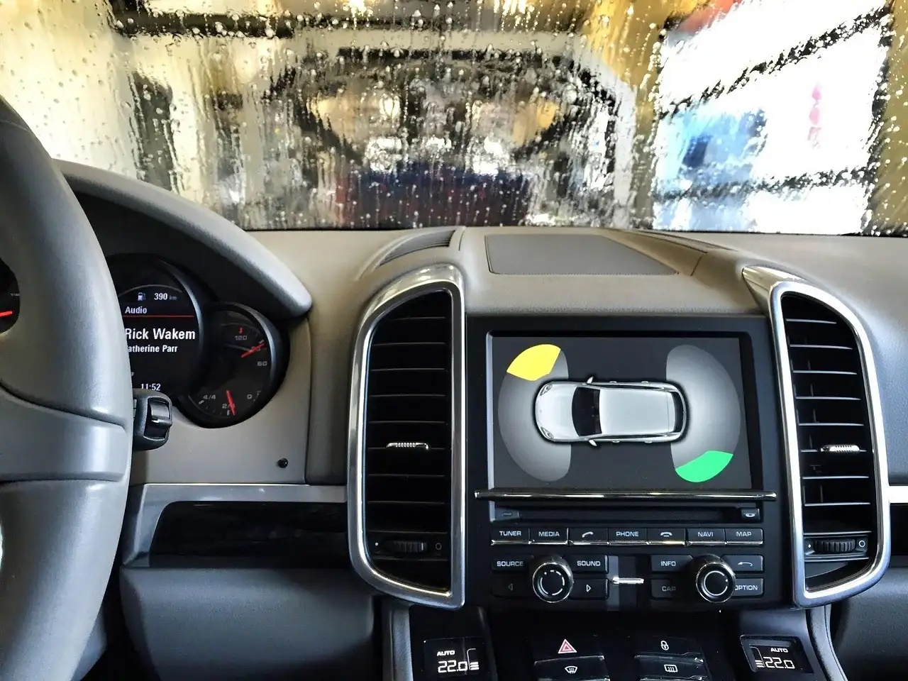 Person wiping a car dashboard with a microfiber cloth in daylight