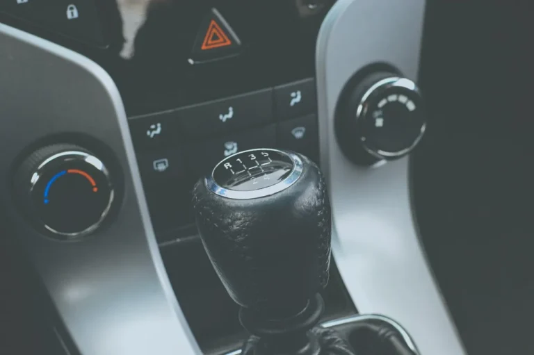 Beginner driver compares manual and automatic car controls inside a compact car.