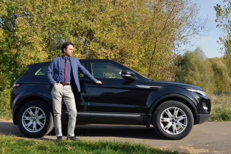 Person comparing car ratings and owner reviews at a table with charts, laptop, and phone