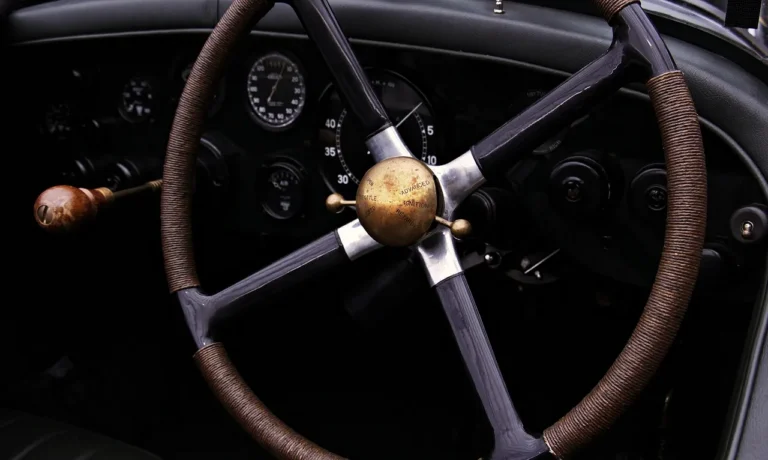 A person inspects a car interior for smoke odor severity with cleaning supplies on the seat.
