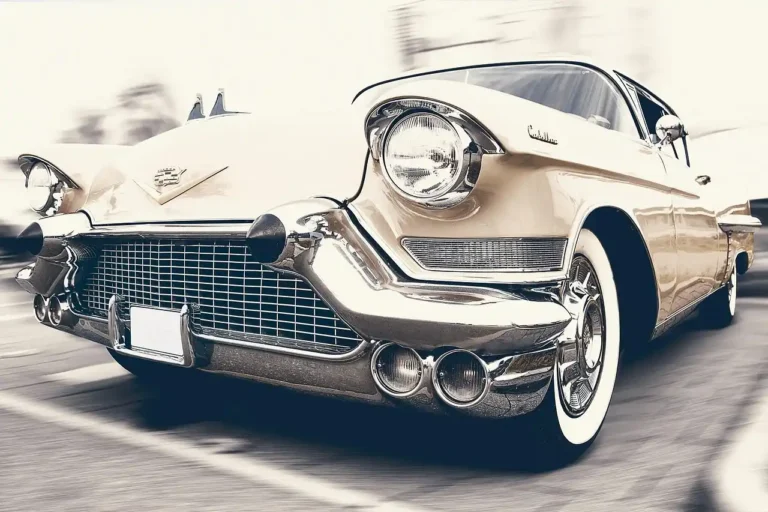 Faded car plastic trim beside a restored section on a parked sedan in daylight