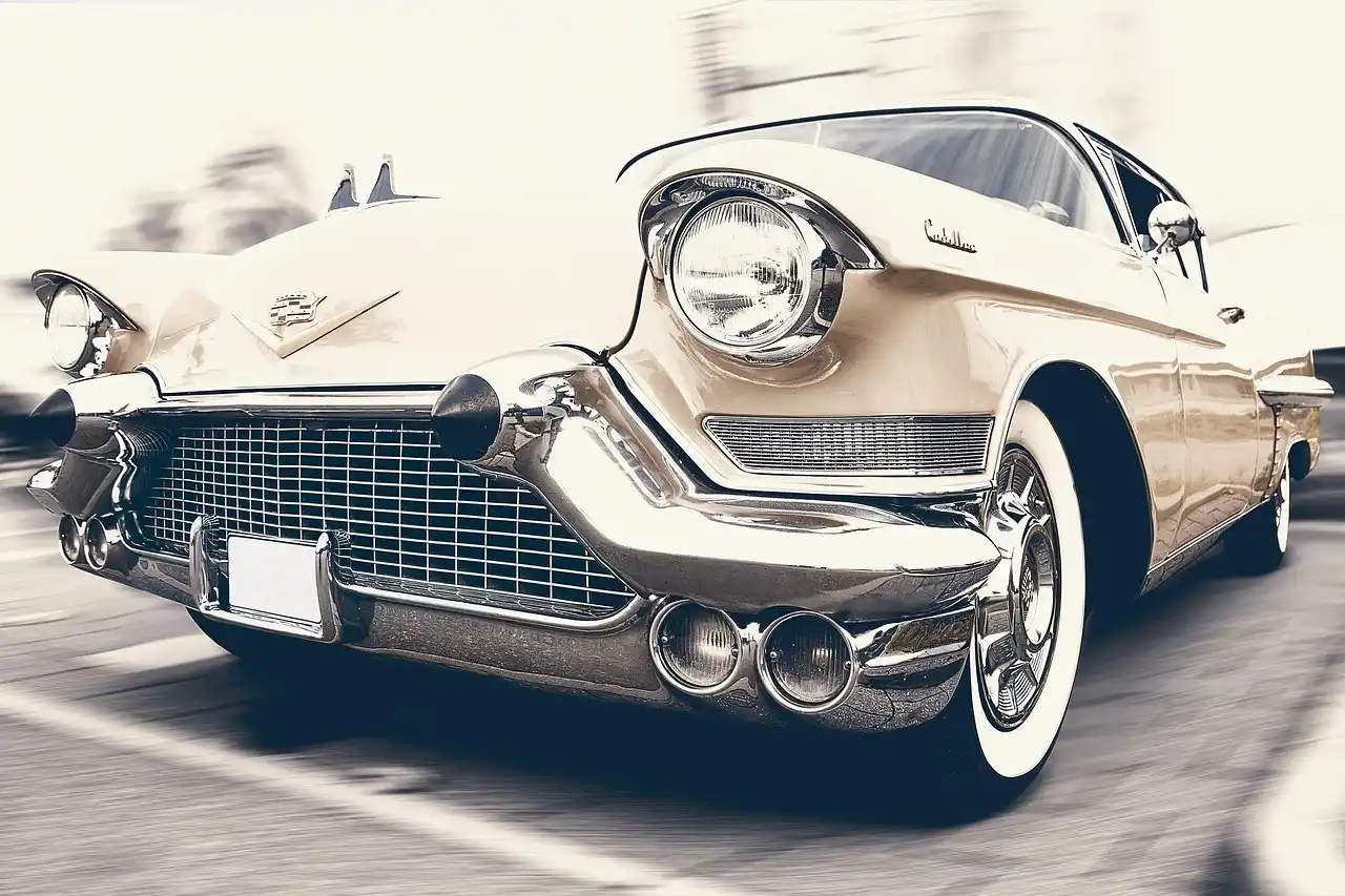Faded car plastic trim beside a restored section on a parked sedan in daylight