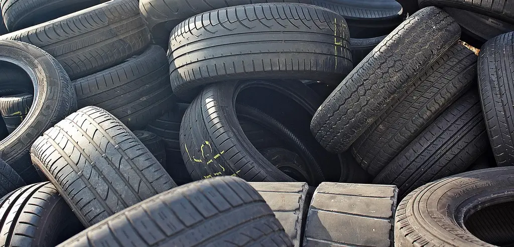 Car tires stacked and stored in a clean garage with shelf space and storage supplies nearby