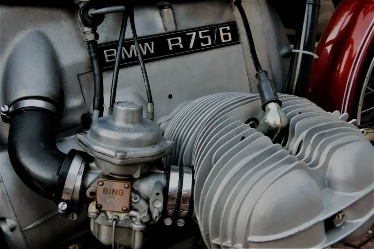 Mechanic adjusting a carburetor in an open engine bay