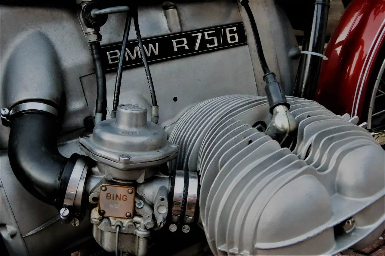 Mechanic adjusting a carburetor in an open engine bay