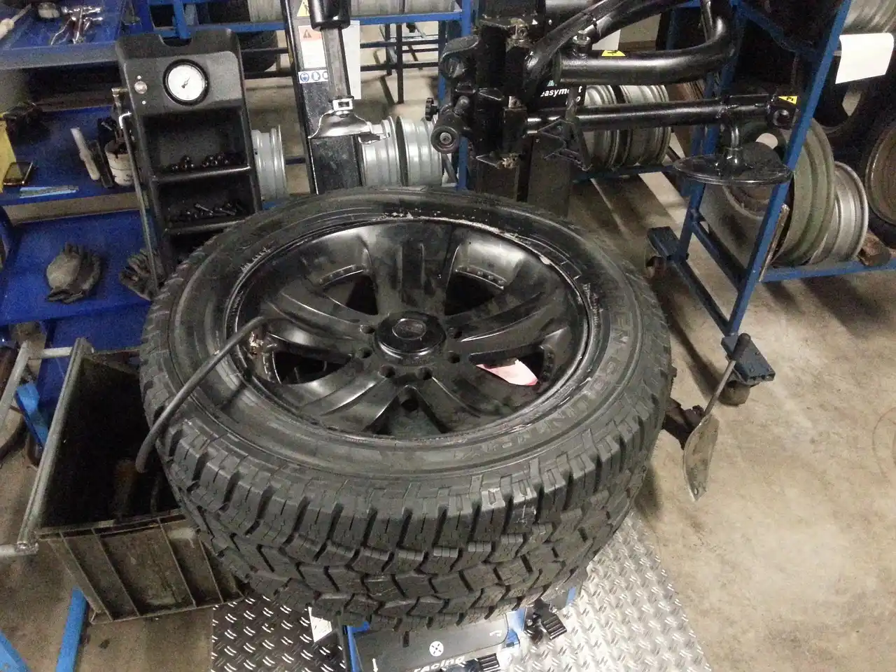 Car with winter tires on one axle and all-season tires on the other, parked on a snowy wet road shoulder
