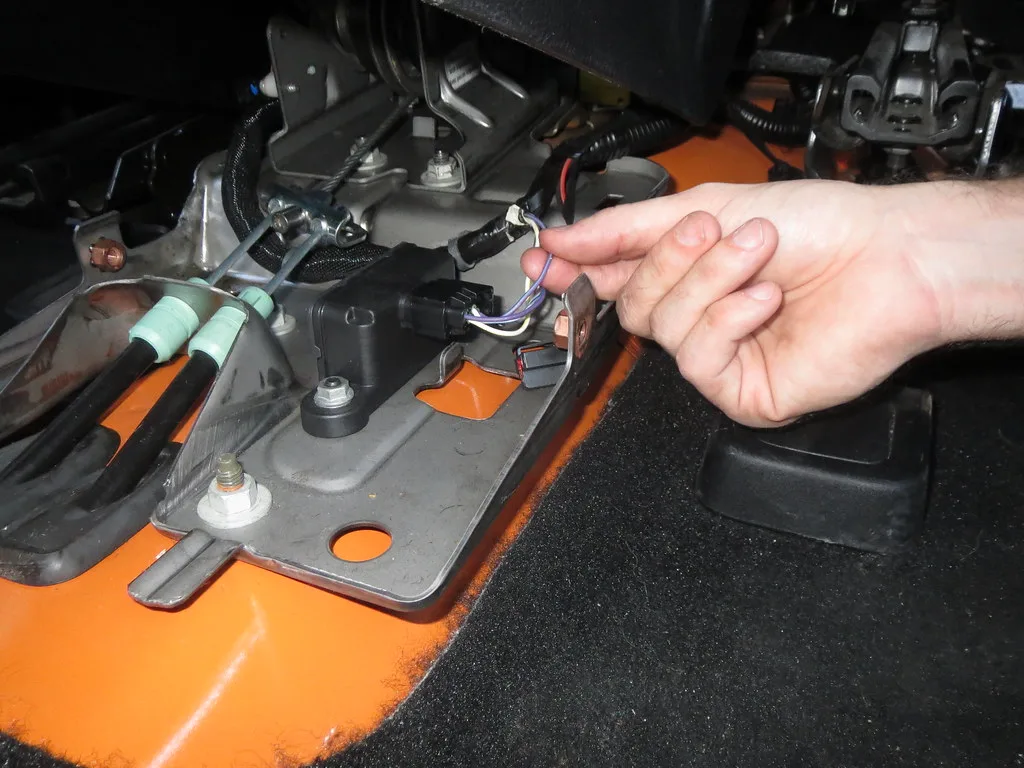 Close-up of rodent-chewed car wires and repair tools on a workbench