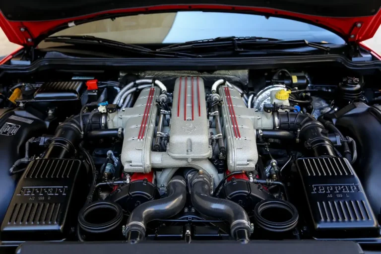 Mechanic checking a car engine bay while a temperature gauge is visible inside the dashboard