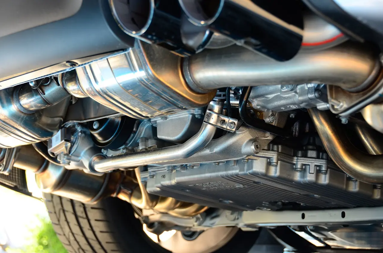 Mechanic using a scan tool beside a sedan with the hood open, diagnosing transmission issues
